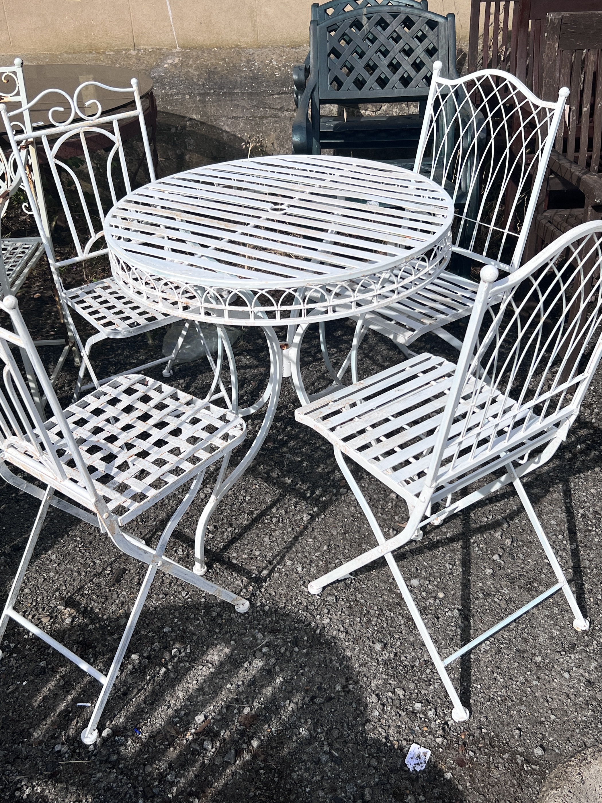 A circular painted aluminium garden table, diameter 74cm, height 77cm, and four folding garden chairs